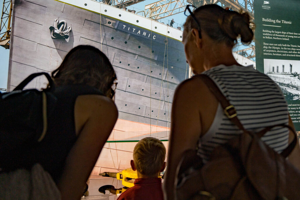 Visitors at the Titanic in Focus exhibition in Liverpool, looking up at the Titanic hull display